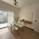 Living comedor con mesa de vidrio y salida al balcón terraza