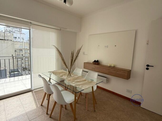 Living comedor con mesa de vidrio y salida al balcón terraza